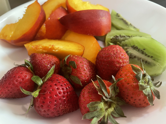 Fruit bowl with strawberries , kiwi, and peaches