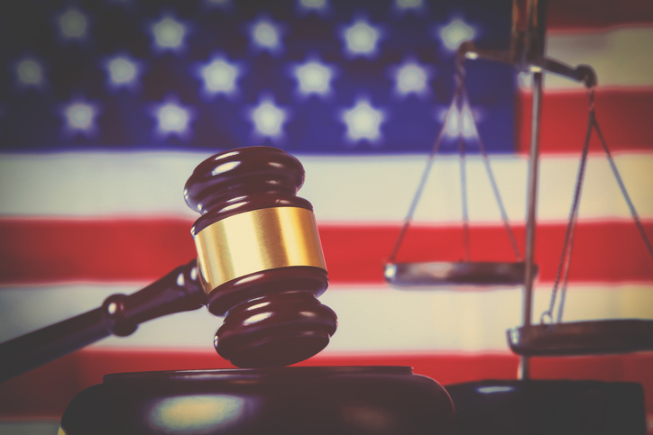 Judge gavel against United States national flag as symbol of judicial system of the USA. Justice, equity, law and human freedom concept.
