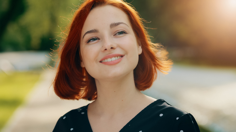 Inspired redhead female model woman attractive girl caucasian young lady inhaling fresh air make deep breath enjoying of blowing spring breeze looking at bright sun shining background fix hair smiling