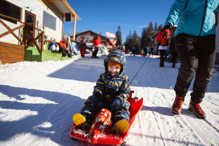 Little boy enjoying being pulled on sled