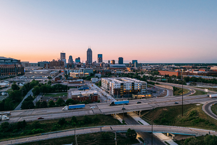 City of Indianapolis Indiana Skyline, Interstate 70 with two blue Semi Trucks transporting goods across the United States