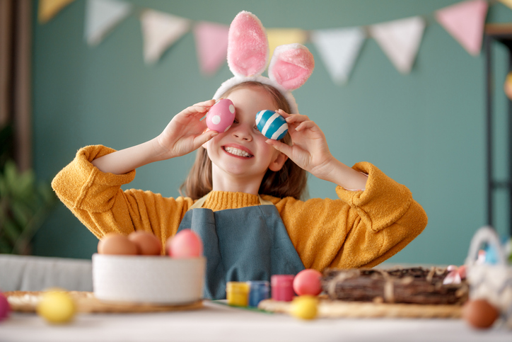child with Easter painting eggs