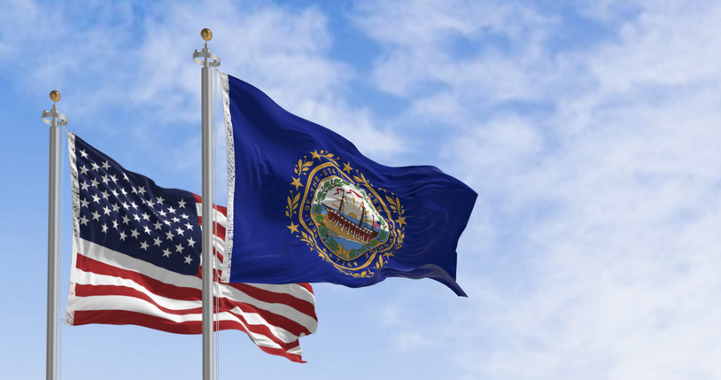 New Hampshire and National US flags waving in the wind on a clear day