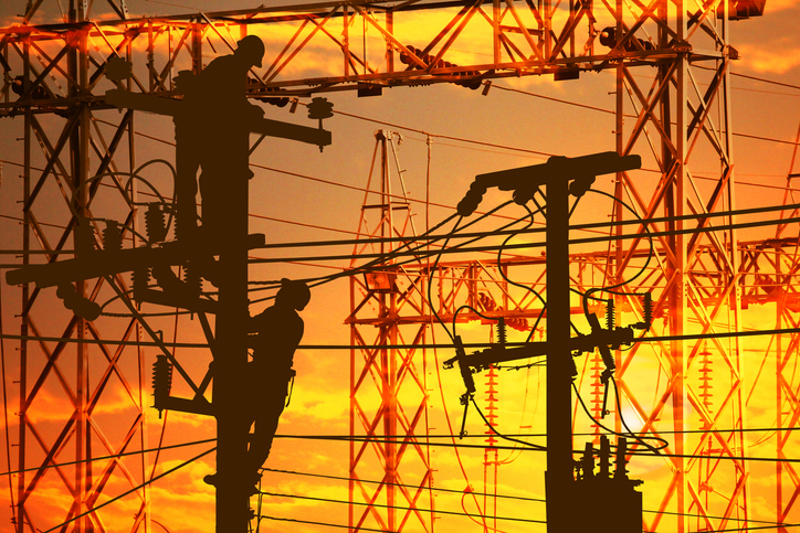 silhouette electric worker work late on electric power supply station