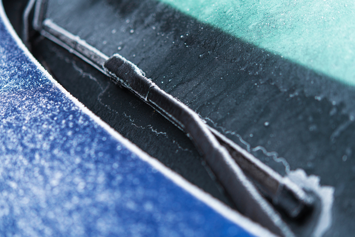 Frost Covers Windshield Wiper on a Car Parked Outside in Winter Morning