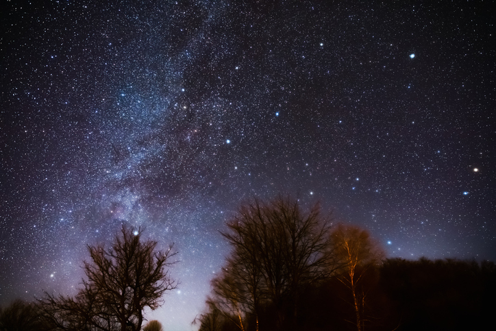 Milky way stars and rural countryside silhouettes.