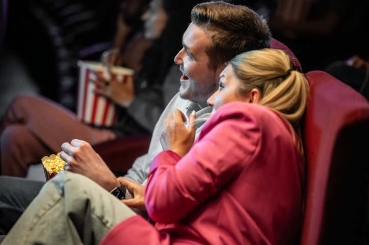 Caucasian Couple Experiencing Intense Movie Moment in Cinema