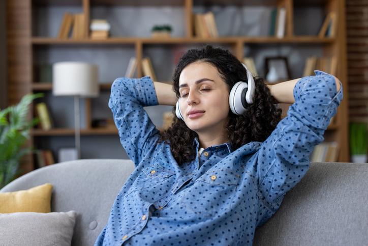 Woman relaxing at home listening to calm music