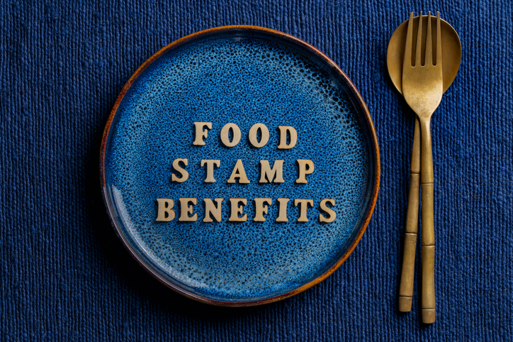 The inscription on the blue plate about food stamp benefits, closeup. The Supplemental Nutrition Assistance Program, known as the Food Stamp Program, is a United States federal government program