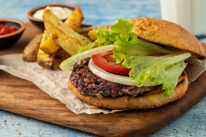Smash burger with cheddar cheese and caramelized onions, served with fries
