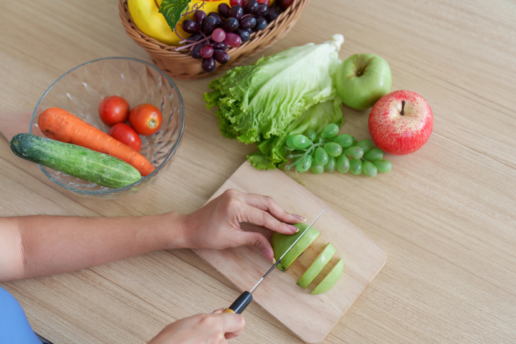 Wellness. Cutting fresh fruits and vegetables for nutritious meal.